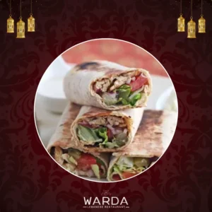 A Chicken Taouk wrap with marinated grilled chicken breast cubes, fresh vegetables, and creamy garlic sauce in soft pitta bread.