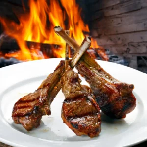 A Plate Of Lahim Meshoué With Marinated Grilled Lamb Cubes, Creamy Hoummos, Grilled Onions, And Tomato.